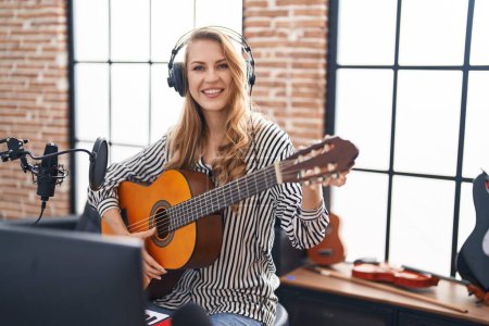 Photo for Young blonde woman musician playing classical guitar at music studio - Royalty Free Image