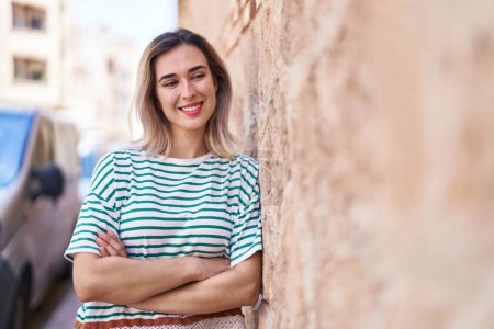 Téléchargez les photos : Young woman smiling confident standing with arms crossed gesture at street - en image libre de droit