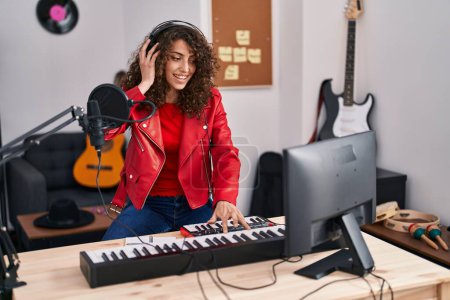 Foto de Joven mujer hispana músico teniendo dj sesión en estudio de música - Imagen libre de derechos