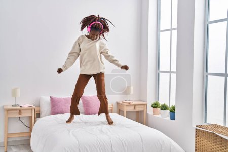 Photo for African american woman smiling confident dancing on bed at bedroom - Royalty Free Image