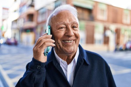Photo for Senior man smiling confident talking on the smartphone at street - Royalty Free Image