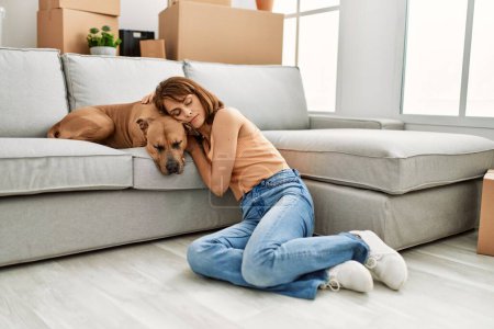 Photo for Young caucasian woman sleeping sitting on floor with dog at home - Royalty Free Image