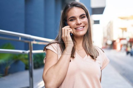 Photo for Young beautiful hispanic woman smiling confident talking on the smartphone at street - Royalty Free Image