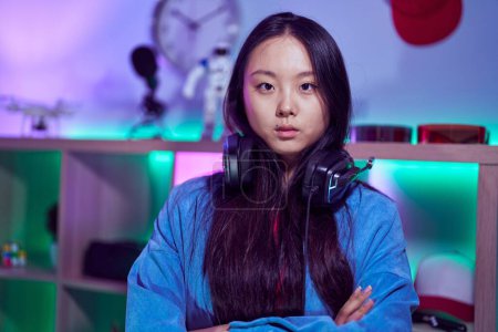 Photo for Young chinese woman streamer standing with arms crossed gesture at gaming room - Royalty Free Image