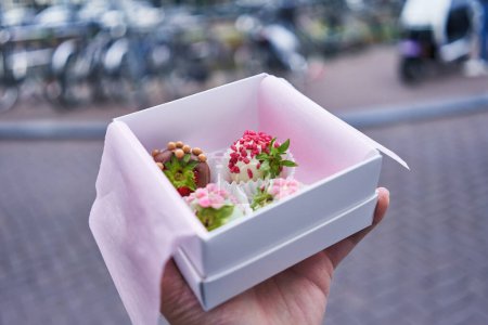 Photo for Hand of man holding box with chocolate dessert at amsterdam - Royalty Free Image
