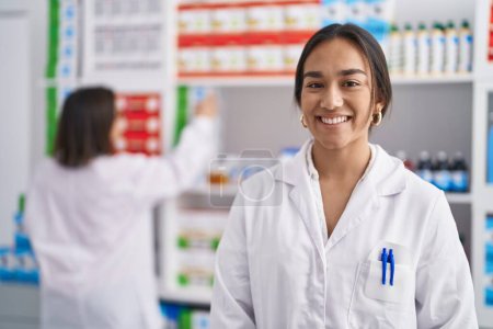 Photo for Two women pharmacist smiling confident working at pharmacy - Royalty Free Image