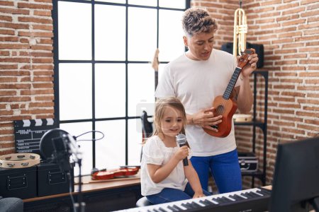 Foto de Padre e hija cantando canciones tocando ukelele en el estudio de música - Imagen libre de derechos