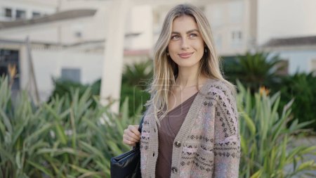 Téléchargez les photos : Jeune femme blonde souriante confiante debout au parc - en image libre de droit