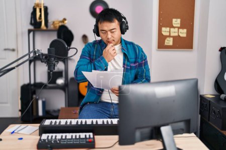 Foto de Joven cantante chino cantando canción en el estudio de música - Imagen libre de derechos