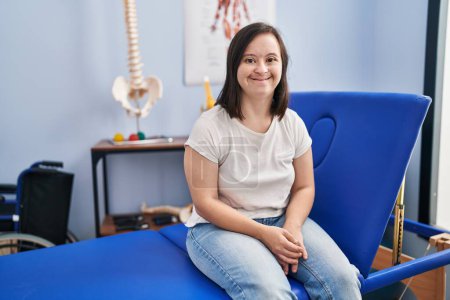 Photo for Hispanic girl with down syndrome at physiotherapy clinic looking positive and happy standing and smiling with a confident smile showing teeth - Royalty Free Image