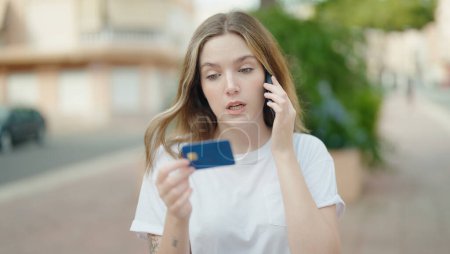 Téléchargez les photos : Jeune femme caucasienne utilisant smartphone et carte de crédit au parc - en image libre de droit