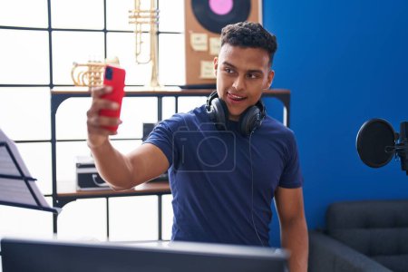 Téléchargez les photos : Jeune artiste latino-américain faire selfie par smartphone au studio de musique - en image libre de droit