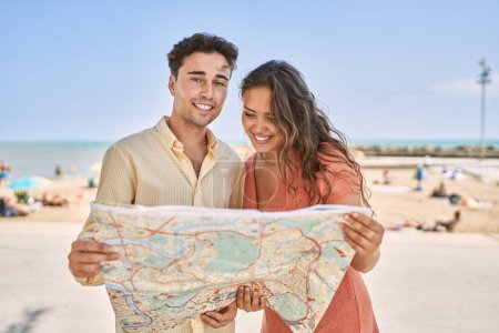 Photo for Man and woman couple smiling confident holding map at seaside - Royalty Free Image