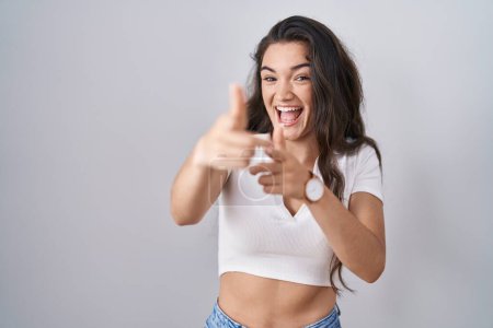 Photo for Young teenager girl standing over white background pointing fingers to camera with happy and funny face. good energy and vibes. - Royalty Free Image