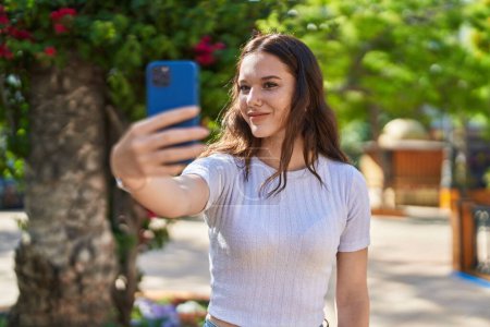 Téléchargez les photos : Young woman smiling confident making selfie by the smartphone at street - en image libre de droit