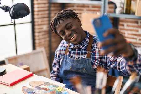 Téléchargez les photos : African american man artist smiling confident make selfie by smartphone at art studio - en image libre de droit