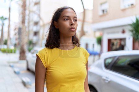 Téléchargez les photos : Young african american woman looking to the side with serious expression at street - en image libre de droit