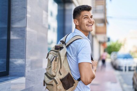 Foto de Young hispanic man student smiling confident standing at street - Imagen libre de derechos