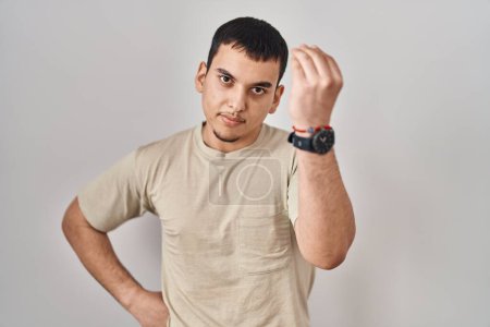 Foto de Hombre árabe joven con camiseta casual haciendo gesto italiano con la mano y los dedos expresión de confianza - Imagen libre de derechos
