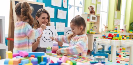 Photo for Teacher with girls sitting on table having emotion therapy at kindergarten - Royalty Free Image