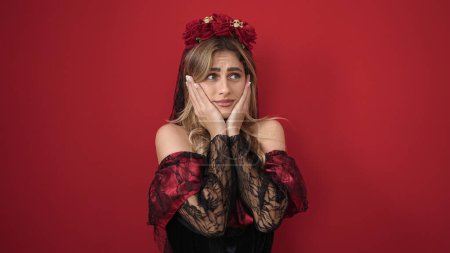 Foto de Young blonde woman wearing katrina costume with fear expression over isolated red background - Imagen libre de derechos
