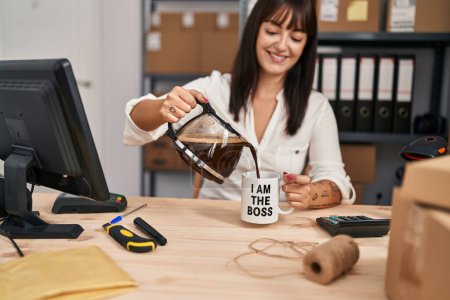 Téléchargez les photos : Jeune belle hispanique femme commerce électronique travailleur d'affaires verser du café sur la tasse au bureau - en image libre de droit