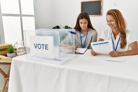 Mutter und Tochter lächeln zuversichtlich bei der Arbeit am Wahlkolleg