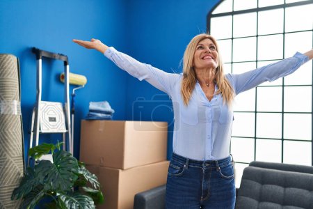 Photo for Middle age blonde woman smiling confident standing with arms open at home - Royalty Free Image