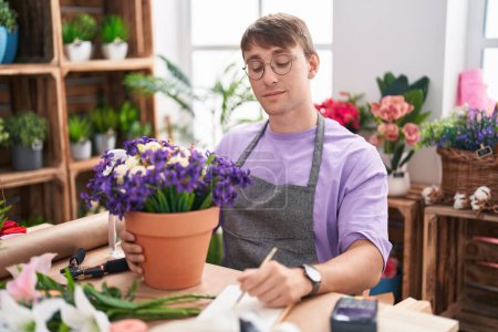 Photo for Caucasian blond man working at florist shop looking sleepy and tired, exhausted for fatigue and hangover, lazy eyes in the morning. - Royalty Free Image