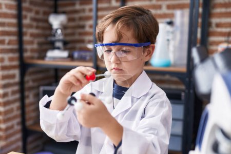 Photo for Adorable hispanic boy student looking molecules at laboratory classroom - Royalty Free Image