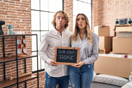 Photo for Young couple moving to a new home making fish face with mouth and squinting eyes, crazy and comical. - Royalty Free Image