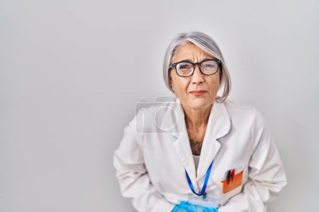 Foto de Middle age woman with grey hair wearing scientist robe with hand on stomach because indigestion, painful illness feeling unwell. ache concept. - Imagen libre de derechos