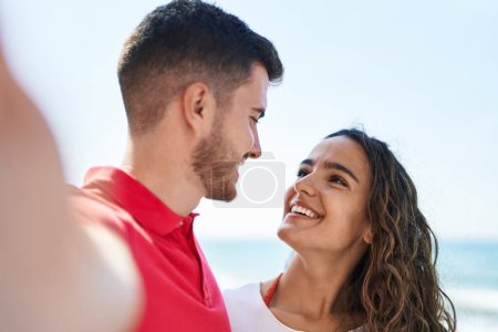 Photo for Young hispanic couple smiling confident make selfie by the camera at seaside - Royalty Free Image
