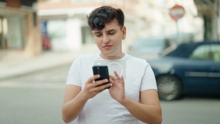 Photo for Non binary man smiling confident using smartphone at street - Royalty Free Image