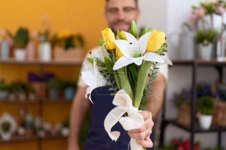 Téléchargez les photos : Moyen Age homme fleuriste tenant bouquet de fleurs à la boutique de fleurs - en image libre de droit