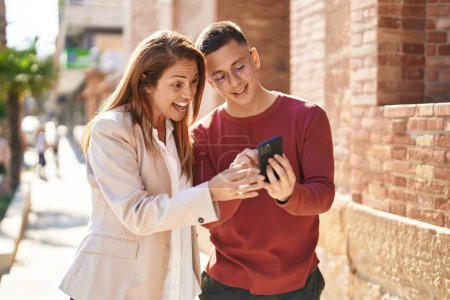 Photo for Man and woman mother and son smiling confident using smartphone at street - Royalty Free Image