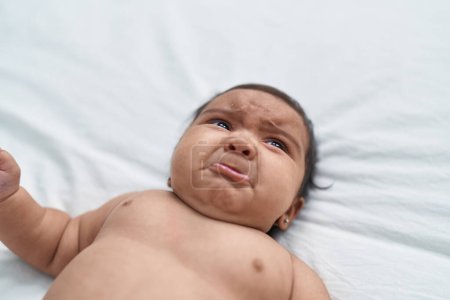 Foto de African american baby lying on bed crying at bedroom - Imagen libre de derechos