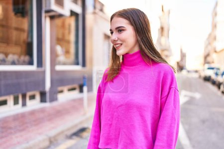Téléchargez les photos : Jeune femme souriant confiant regardant vers le côté à la rue - en image libre de droit