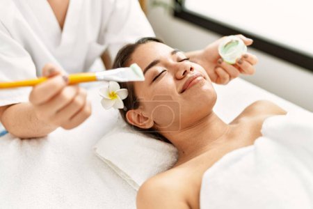 Téléchargez les photos : Young latin woman relaxed having skin face aloe vera treatment at beauty center - en image libre de droit