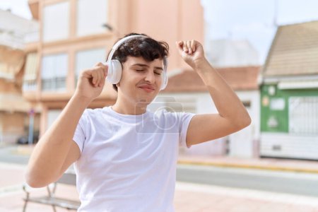 Téléchargez les photos : Non binary man listening to music and dancing at street - en image libre de droit