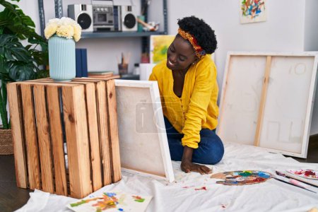 Téléchargez les photos : Jeune artiste afro-américaine souriante confiante dessin au studio d'art - en image libre de droit