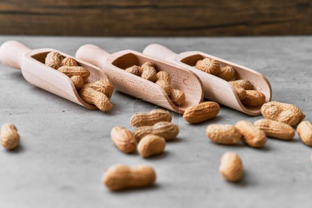 Photo for Image of wooden spoons with peanuts on a concrete surface - Royalty Free Image