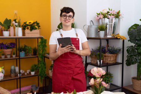Téléchargez les photos : Non binary man florist smiling confident using touchpad at flower shop - en image libre de droit