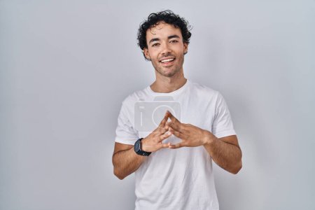 Téléchargez les photos : Hispanic man standing over isolated background hands together and fingers crossed smiling relaxed and cheerful. success and optimistic - en image libre de droit