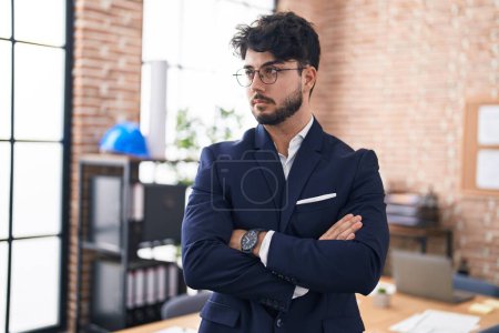 Téléchargez les photos : Jeune homme hispanique travailleur d'affaires debout avec les bras croisés geste au bureau - en image libre de droit