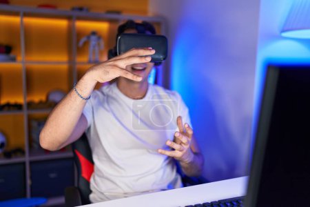 Photo for Young hispanic man streamer playing video game using virtual reality glasses at gaming room - Royalty Free Image