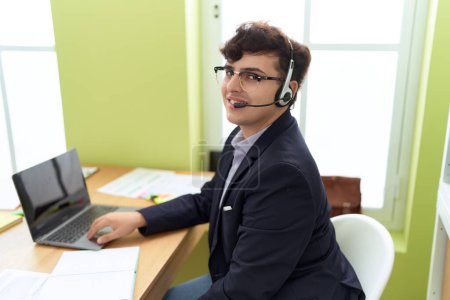 Téléchargez les photos : Non binary man call center agent smiling confident working at office - en image libre de droit