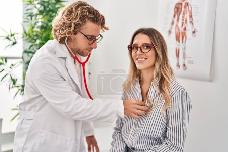 Photo for Man and woman doctor and patient having medical consultation auscultating chest at clinic - Royalty Free Image