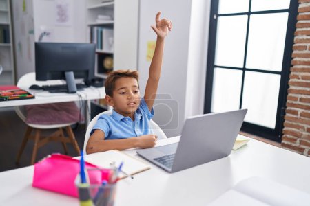 Téléchargez les photos : Adorable élève hispanique garçon utilisant l'ordinateur ayant une éducation à distance en classe - en image libre de droit