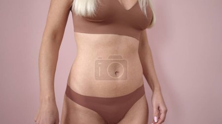 Photo for Young blonde woman wearing lingerie over isolated pink background - Royalty Free Image